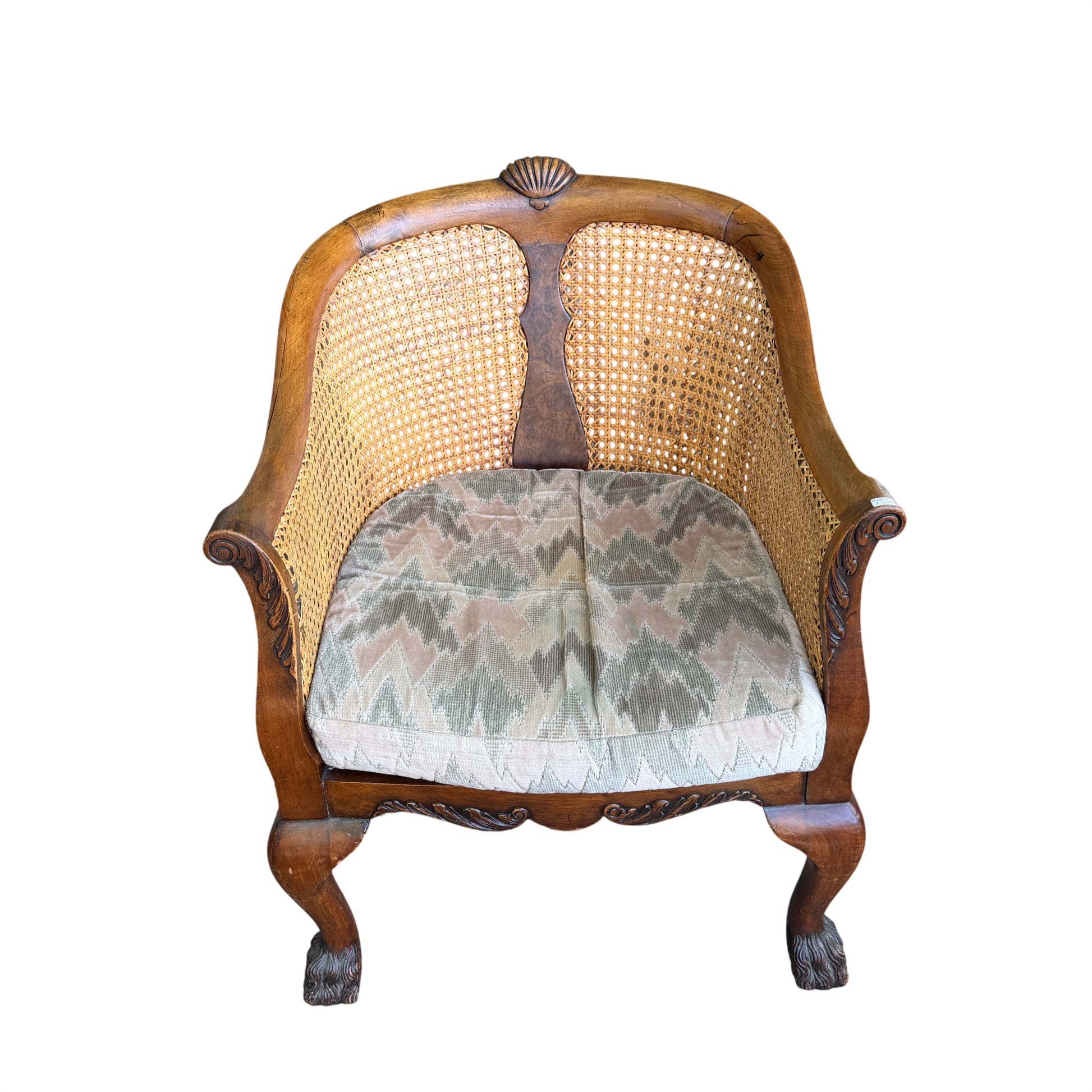 Detail of carved apron and scrolled carving below the seat of cane armchair