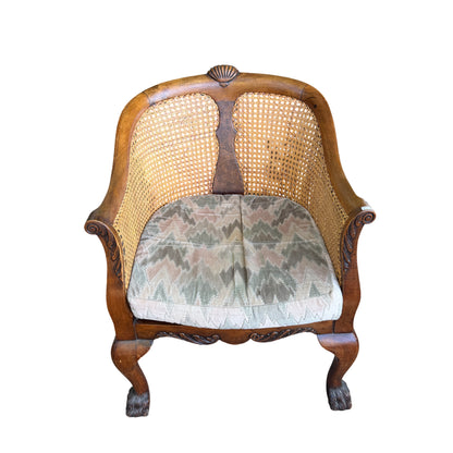 Detail of carved apron and scrolled carving below the seat of cane armchair