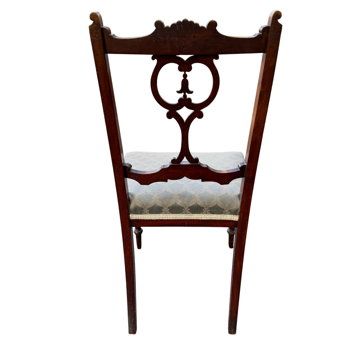 Full-height view of Edwardian dining chair with carved back and turned legs against van