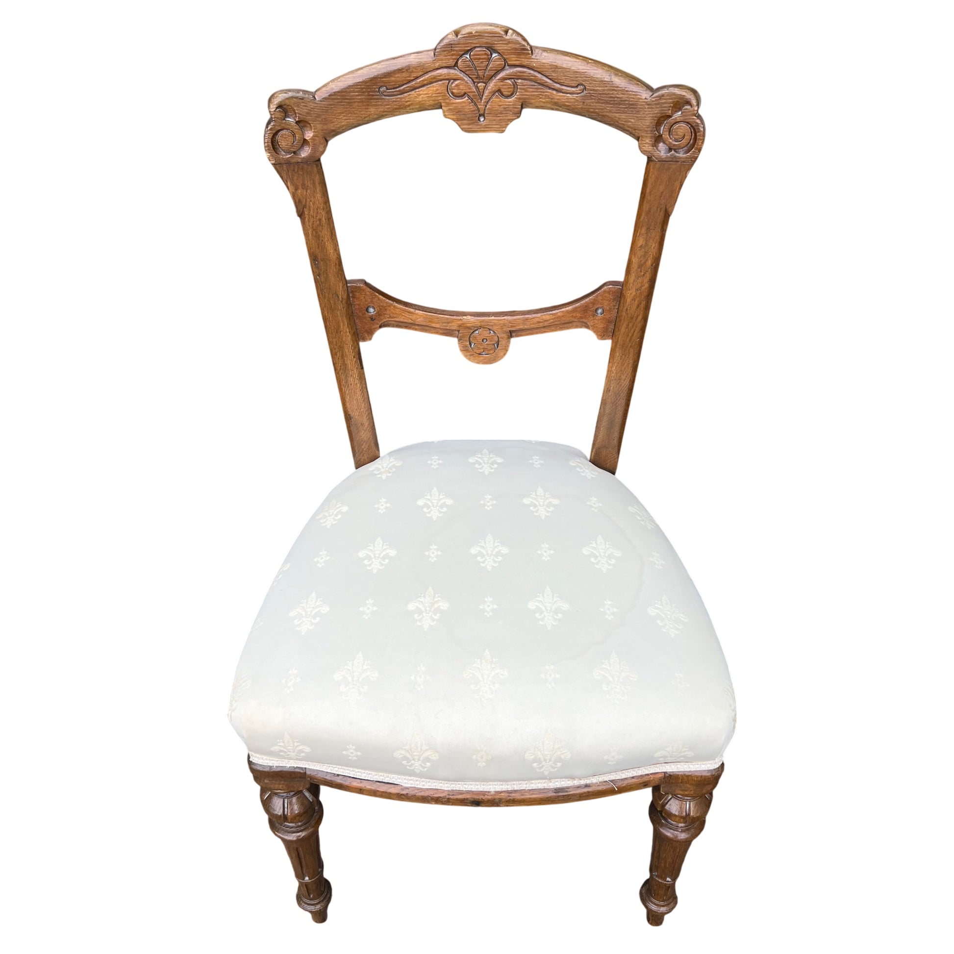 Victorian oak dining chair with carved decorative top rail and cream upholstered seat