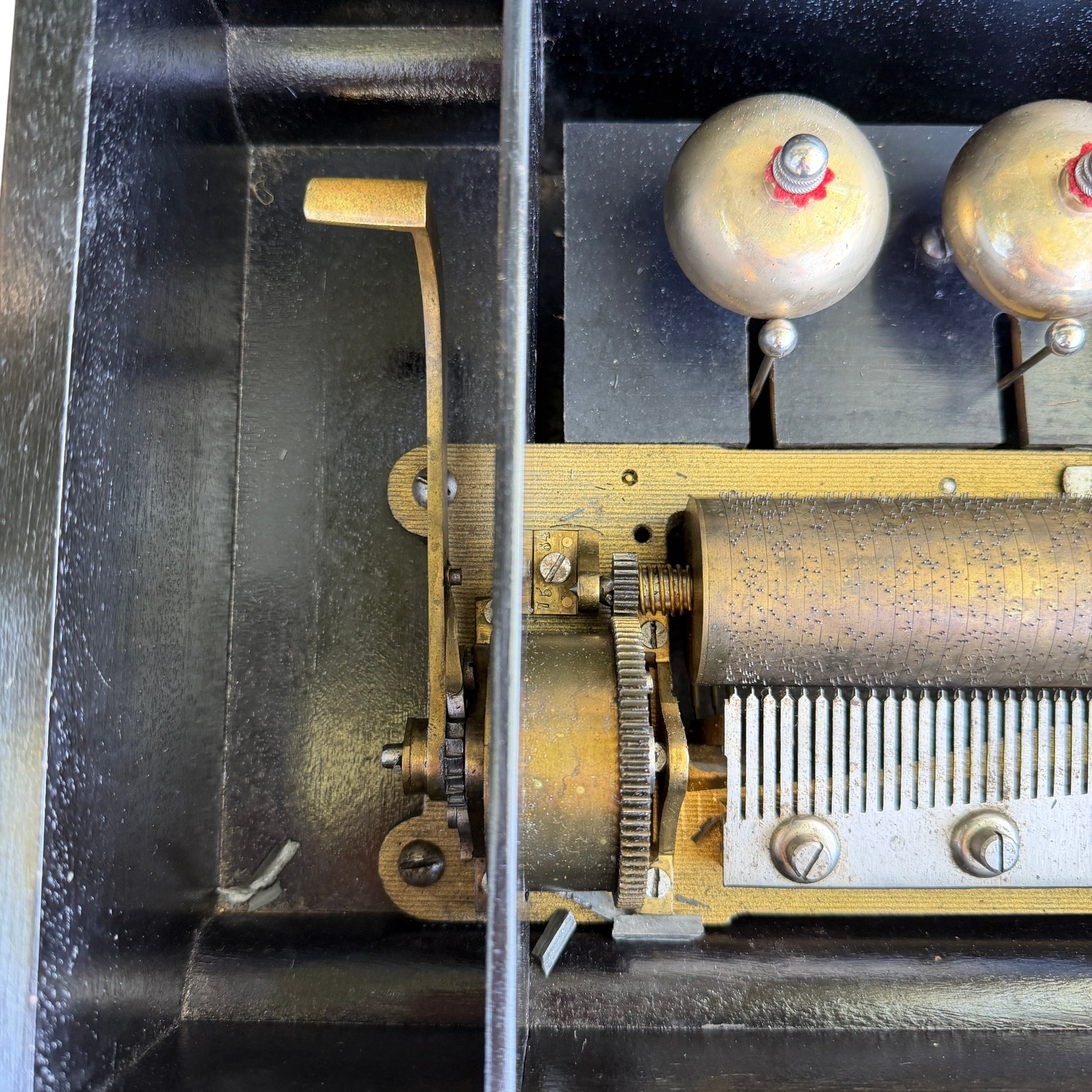 Top view of music box interior with cracked inner glass dust cover and beading