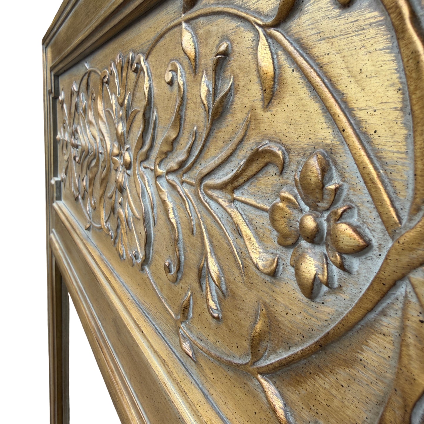 Detail of carved floral panel on gold overmantel mirror with bevelled glass