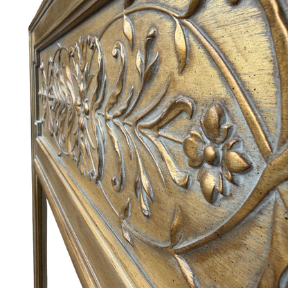 Detail of carved floral panel on gold overmantel mirror with bevelled glass