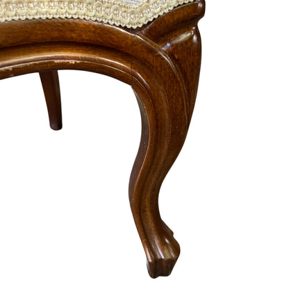 Detail of decorative braid trim and cream upholstery on button-back chair