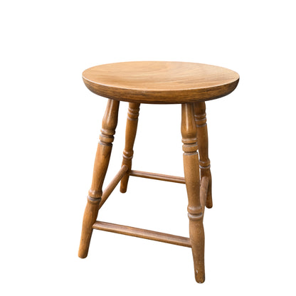 Contemporary country wooden round stool with turned legs and stretchers in a natural finish