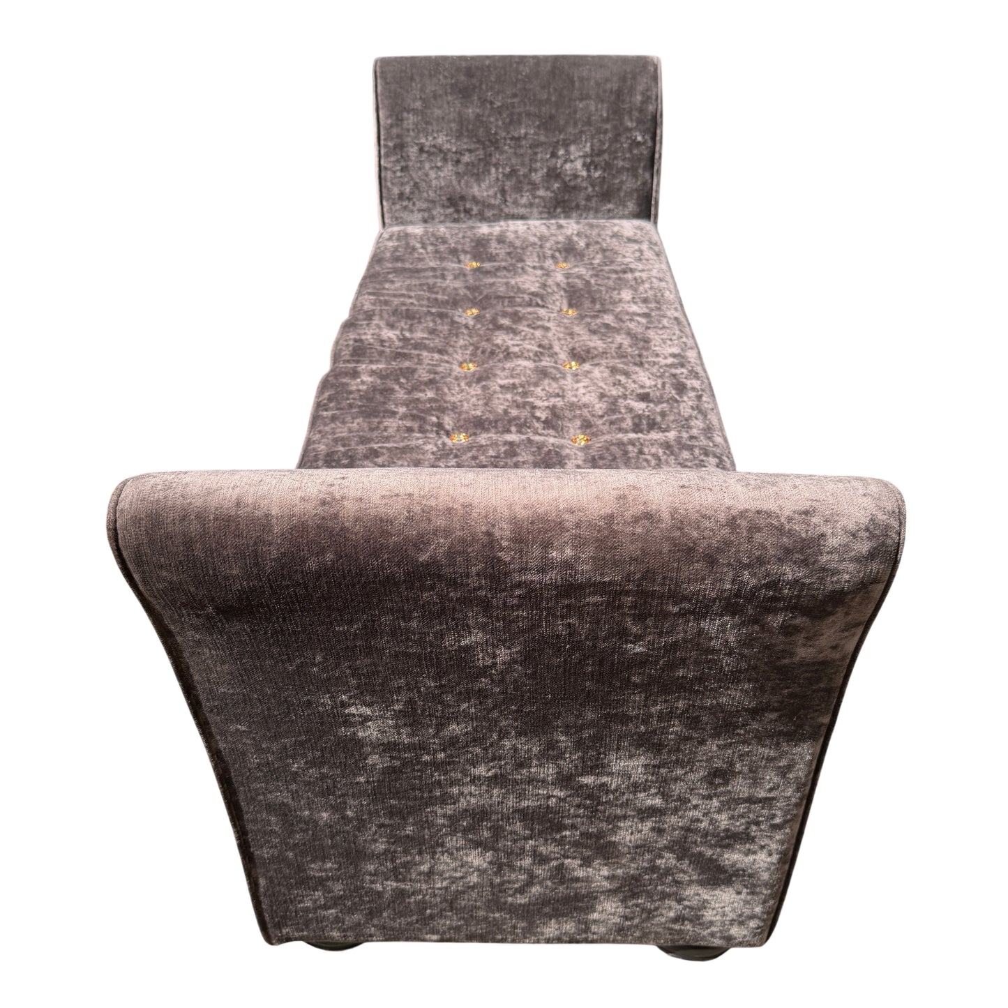 Button tufting detail on the seat of a grey velvet chaise longue daybed