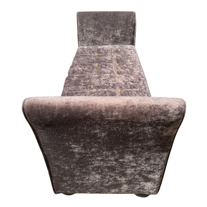Button tufting detail on the seat of a grey velvet chaise longue daybed