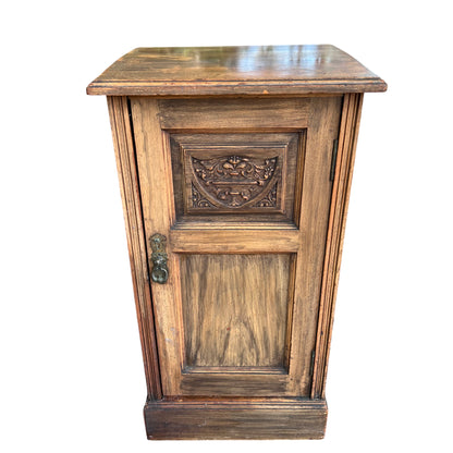 Narrow vintage carved oak bedside cabinet with carved front panel and metal drop handle