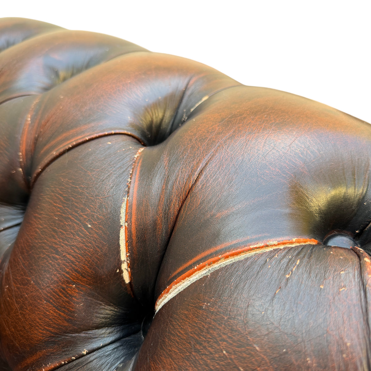 Top view of curved button-back and tufted leather on a Chesterfield armchair