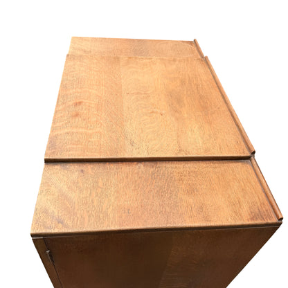 Base of oak linen press showing turned bun feet and plinth