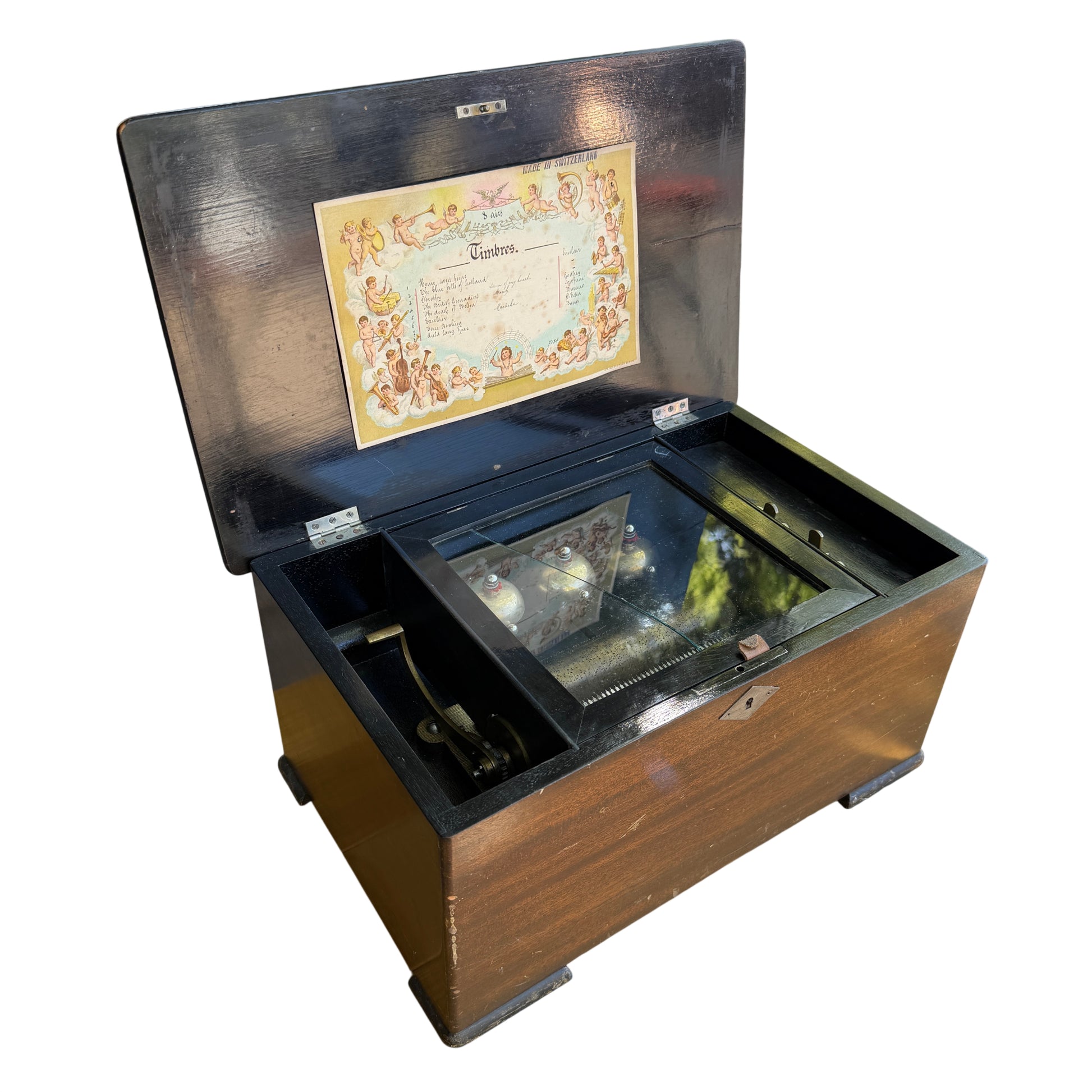 Antique Swiss 8-air cylinder music box in wooden case with lid open showing tune sheet and three visible bells