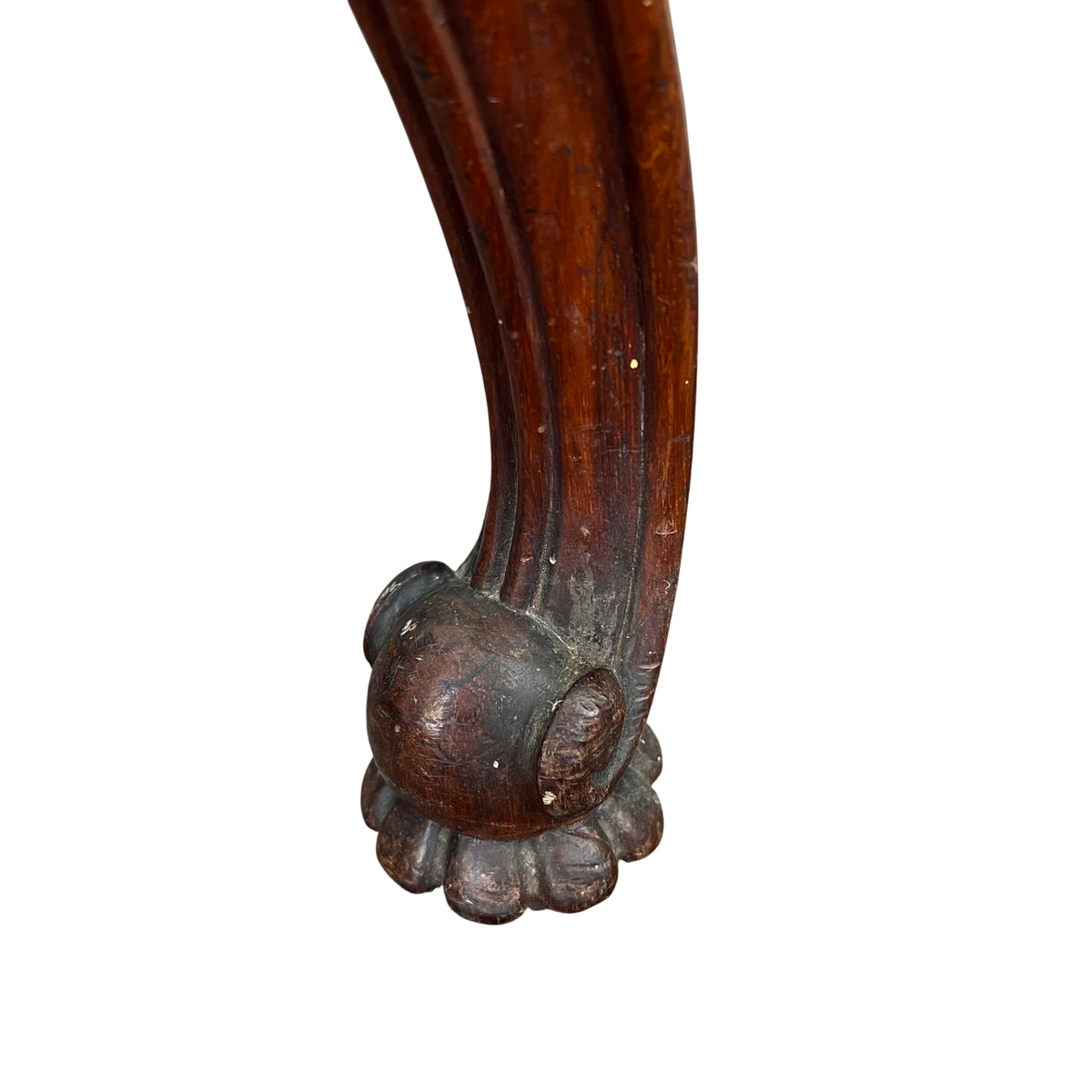 Side view of upholstered Victorian stool with carved leg and claw foot detail