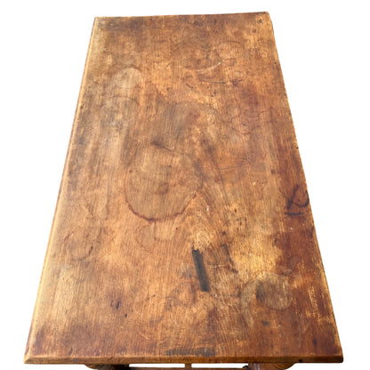 Edge detail of pine tabletop with worn finish and scuffs