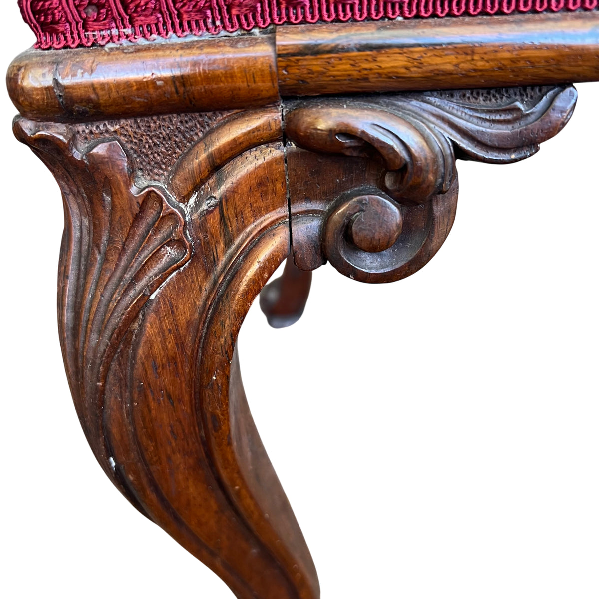 Front view of Victorian mahogany stool showing carved apron and small front split