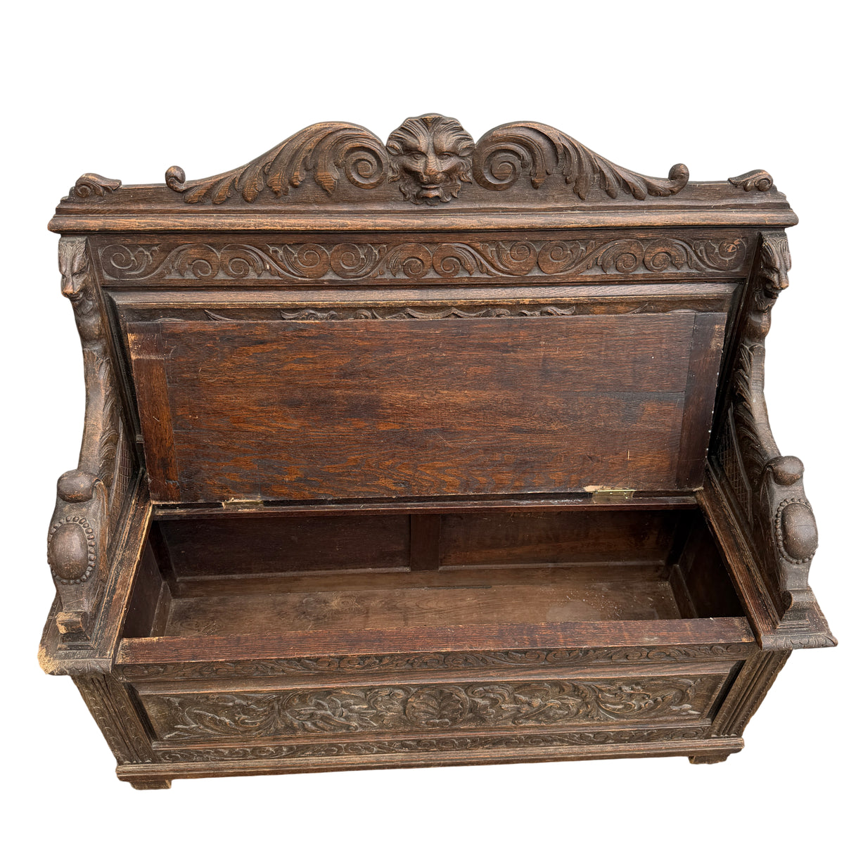 Close-up of worn carved arm and chipped corner on Victorian oak bench