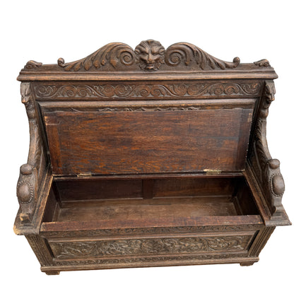 Close-up of worn carved arm and chipped corner on Victorian oak bench