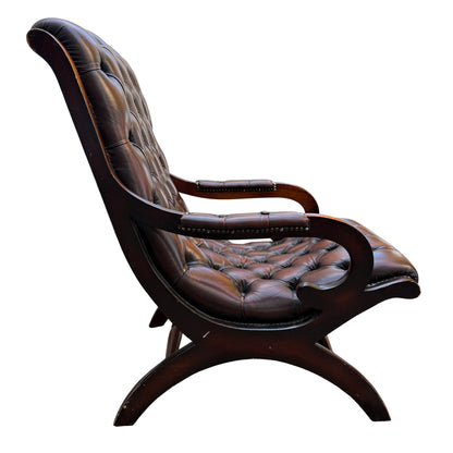 Lower section and turned stretcher of wooden frame under a leather armchair