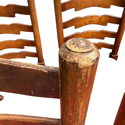 Group of vintage ladderback dining chairs with worn oak finish and red upholstery