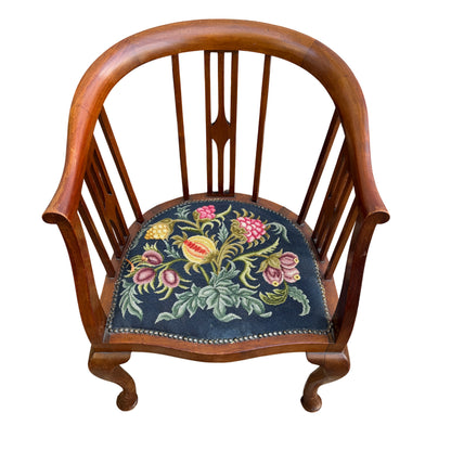 Side view of stained hardwood tub armchair showing shaped arm and slatted back