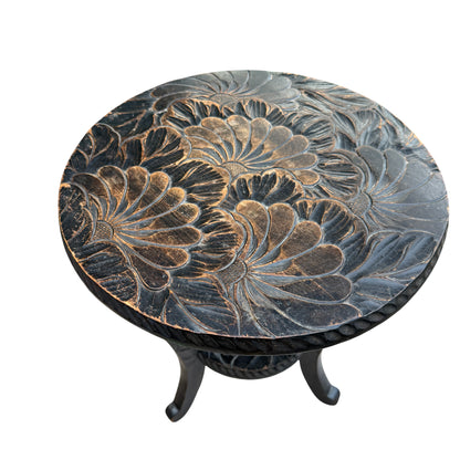 Close-up of carved petal and floral motif on a dark hardwood side table top