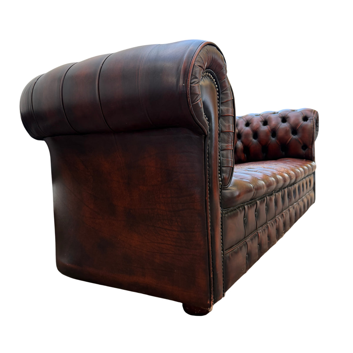 Detail of button tufting and aged leather patina on vintage Chesterfield