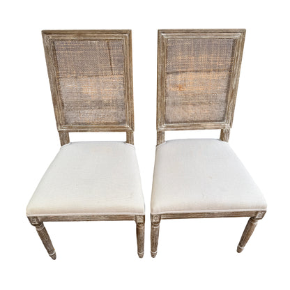 French-style dining chair with rattan cane back and distressed whitewashed wood frame