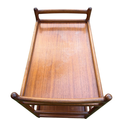 Teak trolley showing black laminate shelf and lower wooden shelf