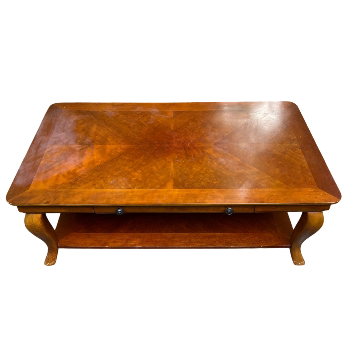 Edge detail with visible small chips and finish wear on wood-veneer coffee table