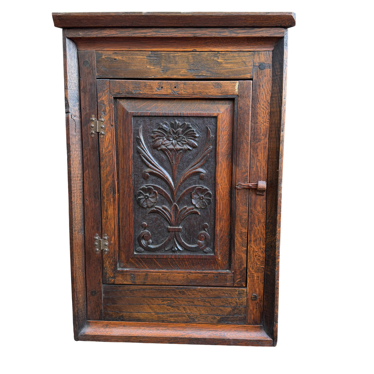 Carved floral panel on oak corner wall cabinet in Arts & Crafts style