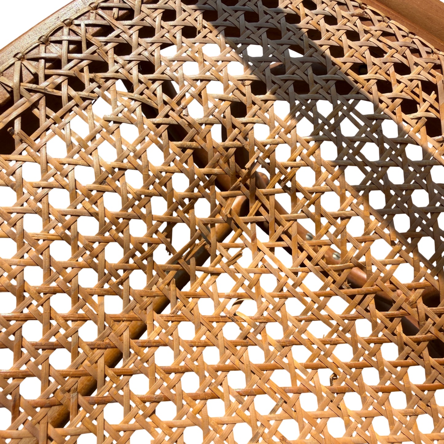 Close-up of caned seat weave and timber frame on a vintage rocking chair