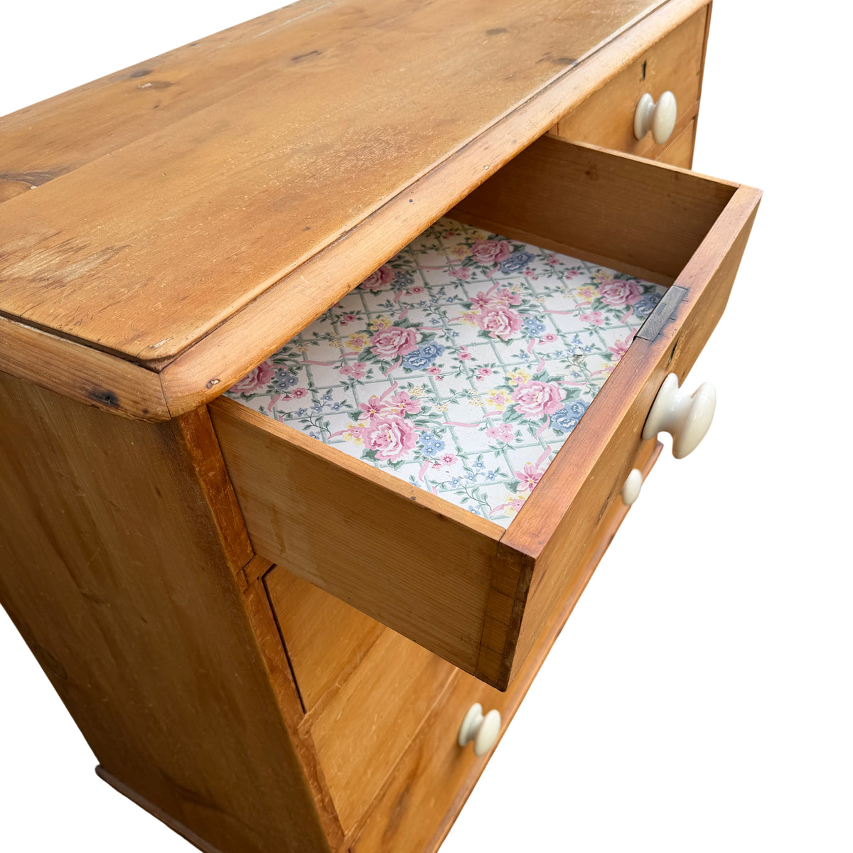 White ceramic knobs fitted to a solid pine chest of drawers