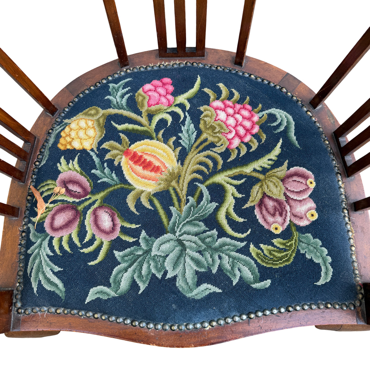 Needlepoint upholstered round seat with decorative nailhead trim on wooden armchair