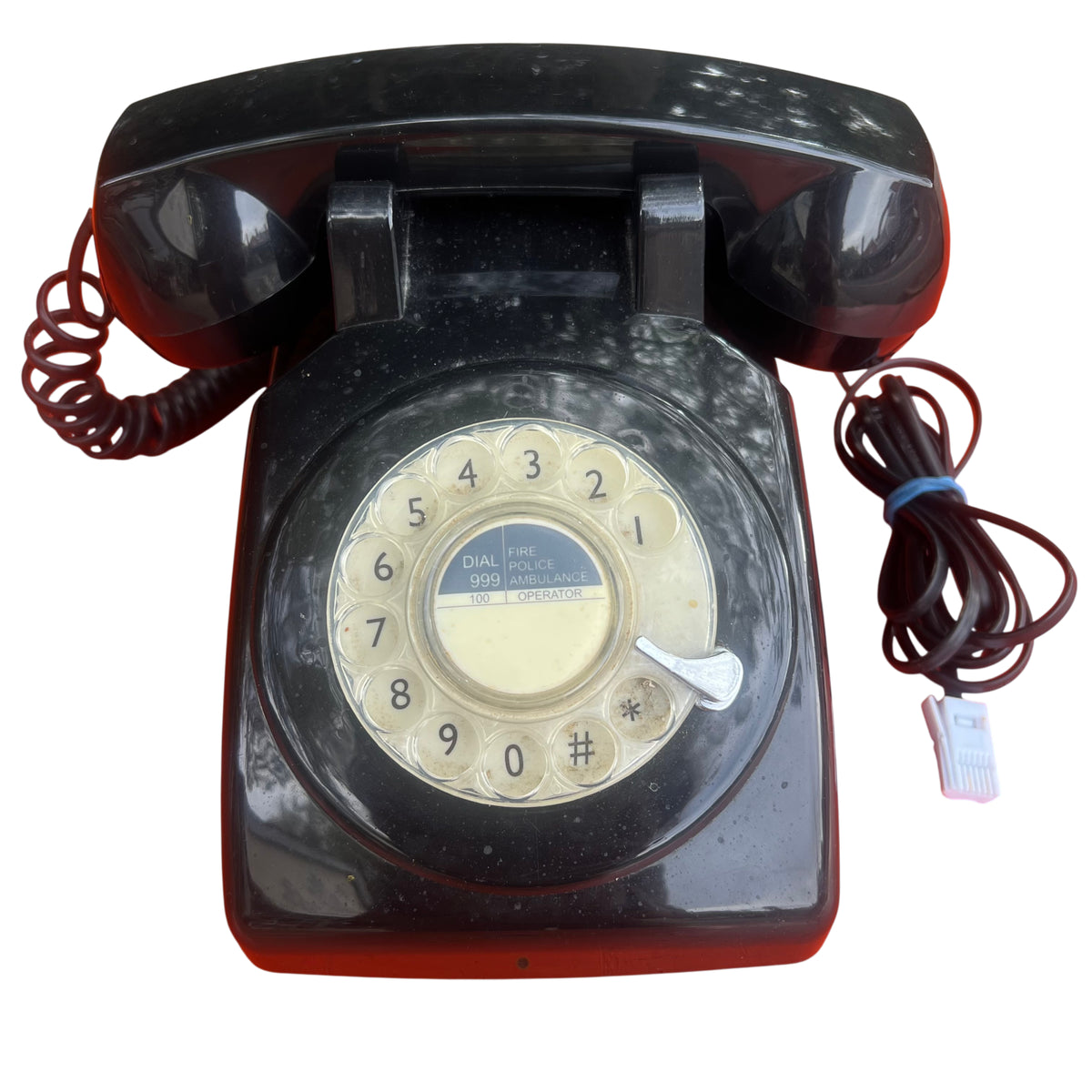Close-up of vintage bakelite handset and cradle with coiled cord