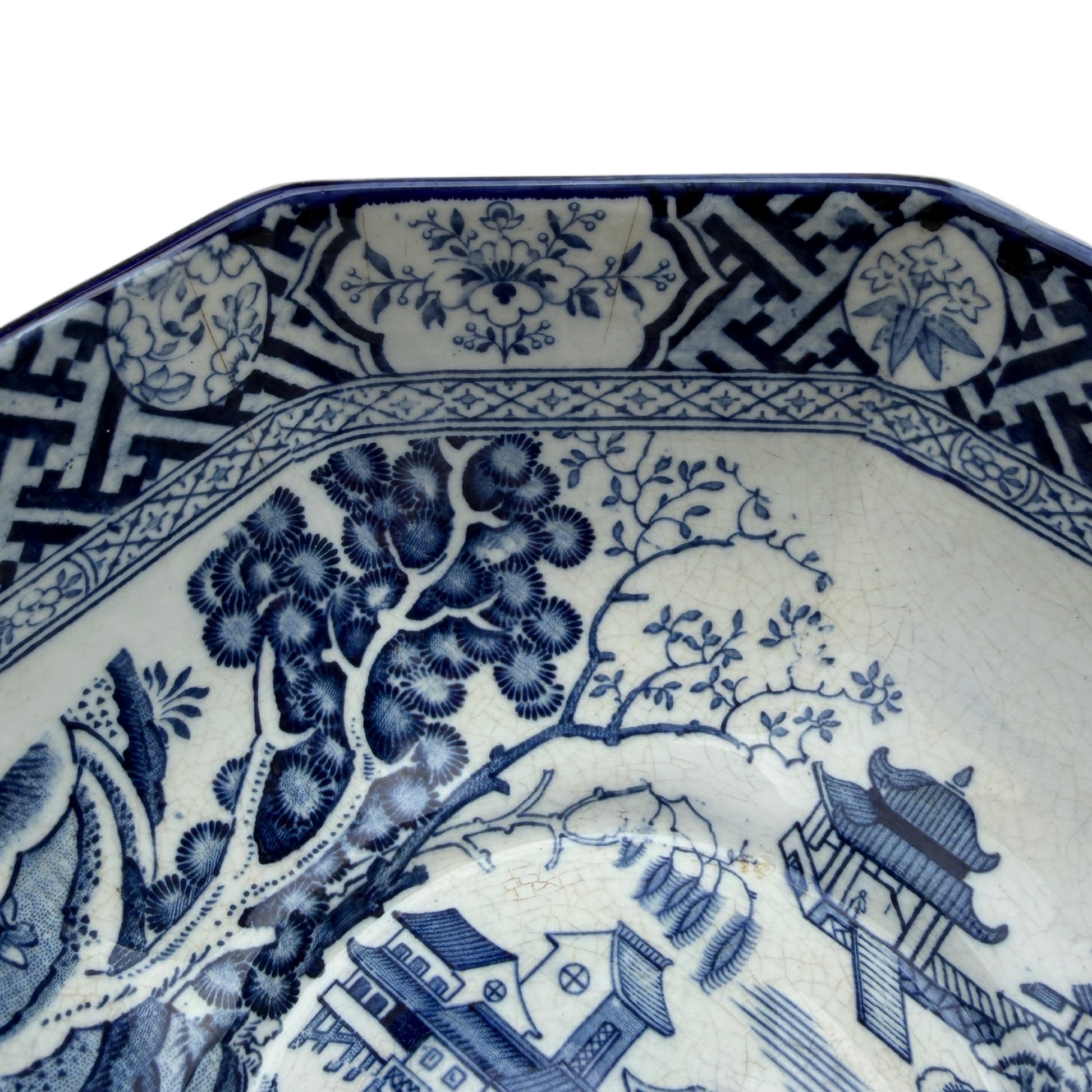 Side view showing decorated octagonal rim and transferware panels on porcelain bowl