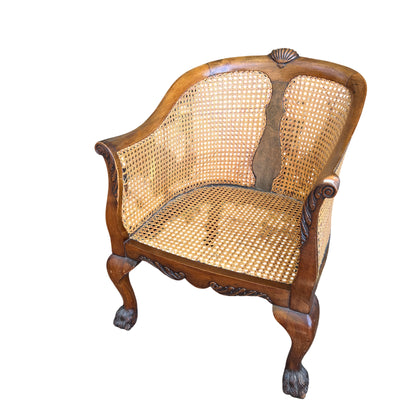 Vintage cane-back carved wood armchair with carved claw feet and loose upholstered cushion