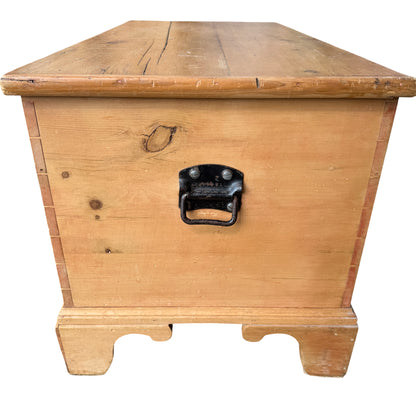 Base and shaped feet of pine blanket box showing simple carved feet