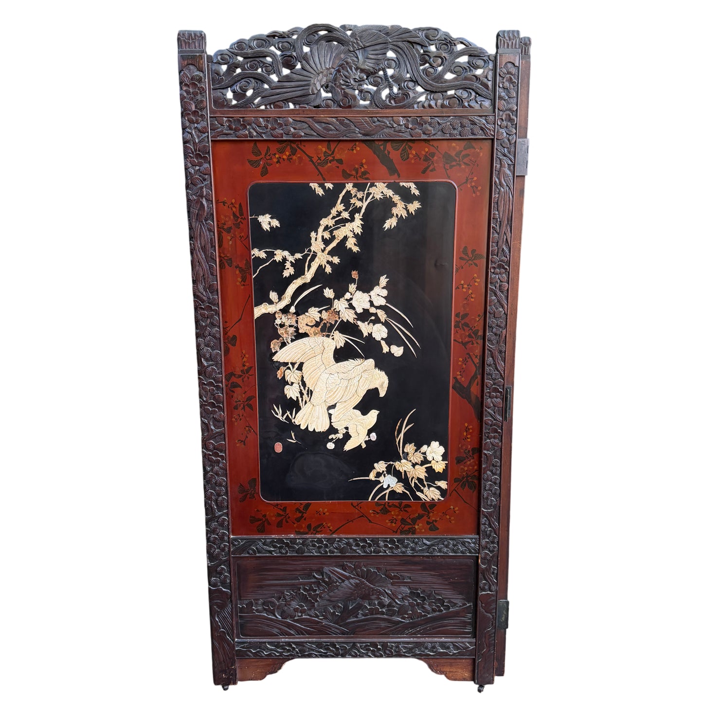 Black lacquer field with pale carved petals and botanical inlay on a folding screen panel
