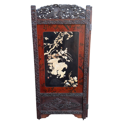 Black lacquer field with pale carved petals and botanical inlay on a folding screen panel