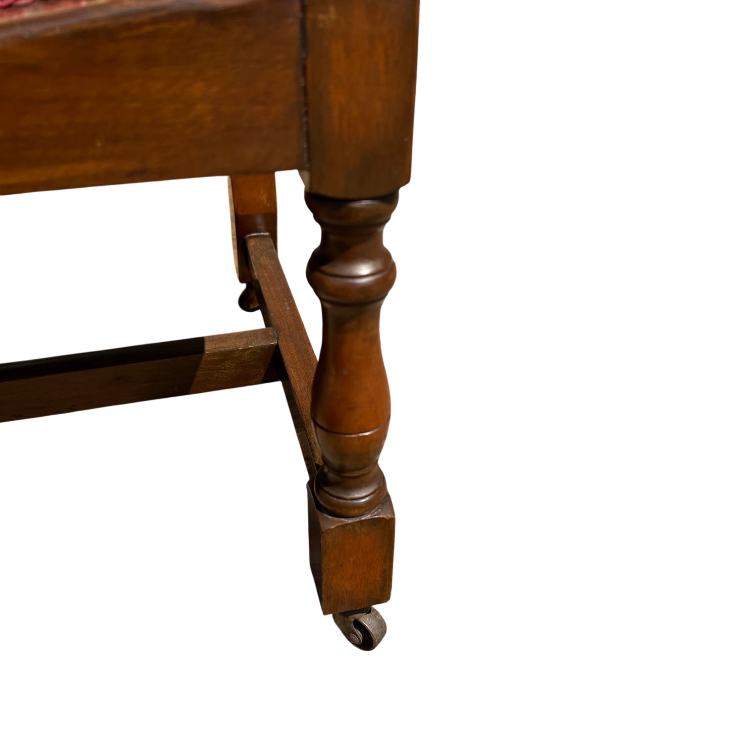 Solid wood armchair with scalloped back and castor on front leg visible