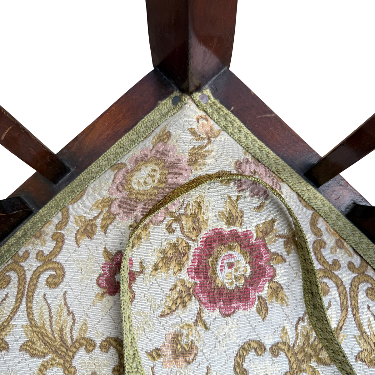 Detail of upholstered seat fabric and green trim on vintage corner chair