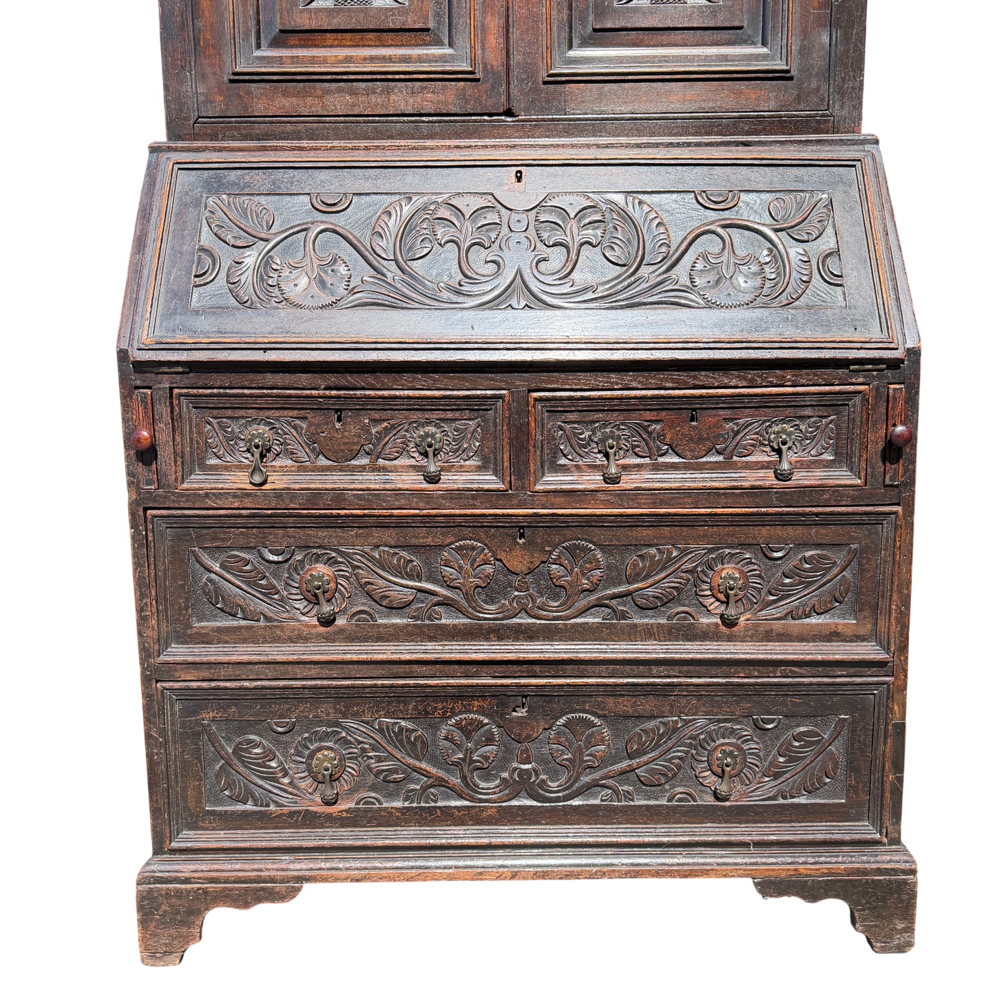 Two-piece oak bookcase and secretaire showing carved floral panels