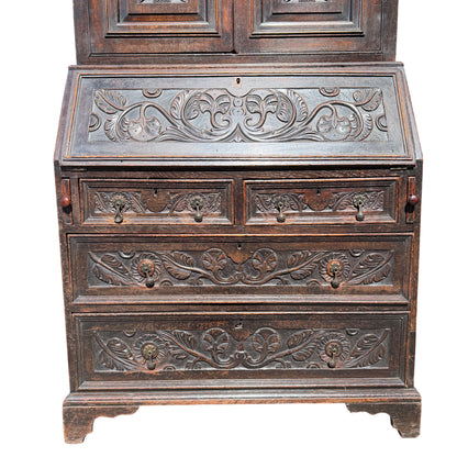 Two-piece oak bookcase and secretaire showing carved floral panels