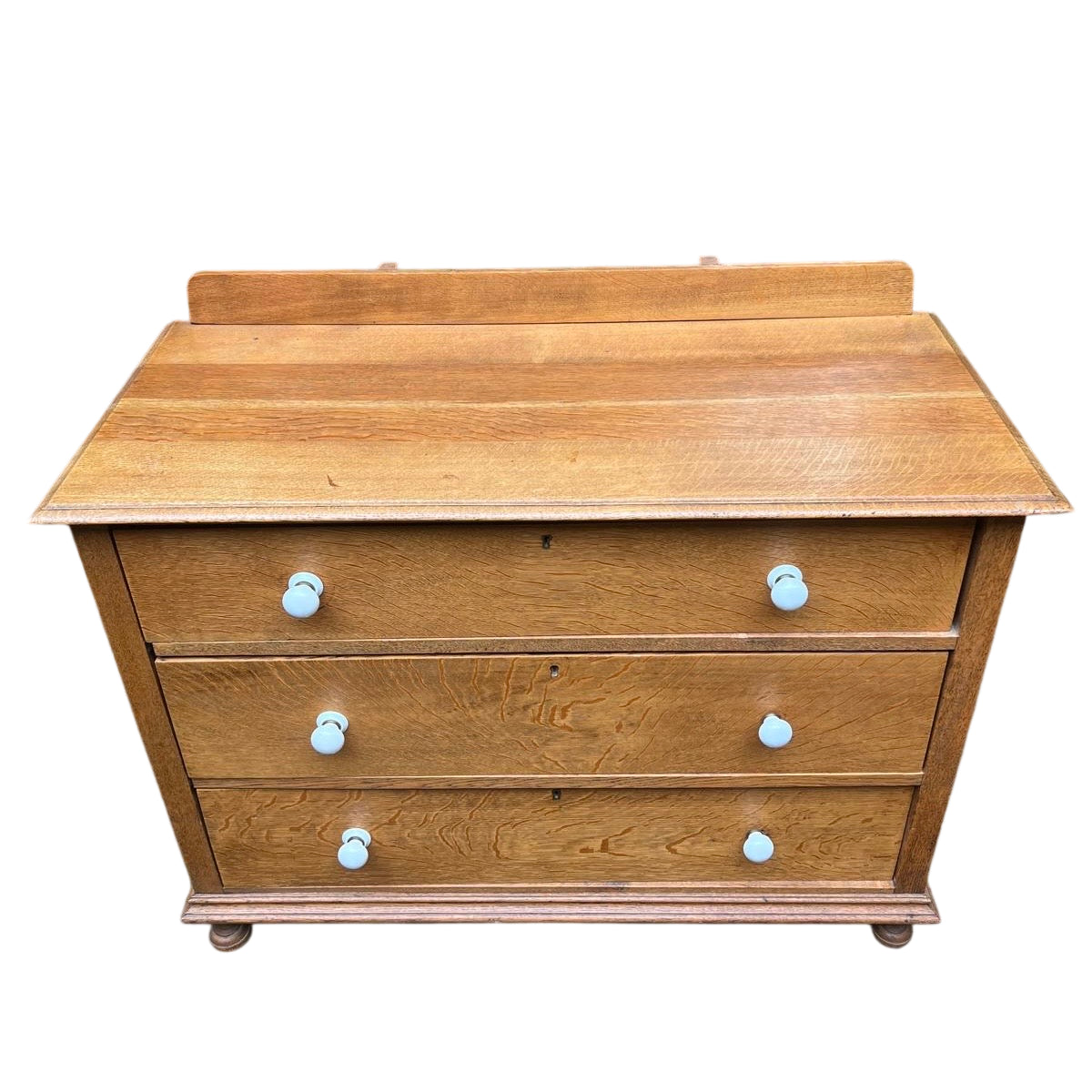 Front view oak three-drawer chest in Arts & Crafts style with shaped backboard