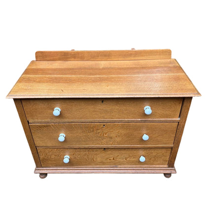 Front view oak three-drawer chest in Arts & Crafts style with shaped backboard