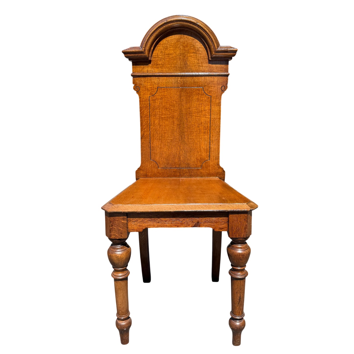Front view of a Victorian oak hall chair showing shaped back and oak seat