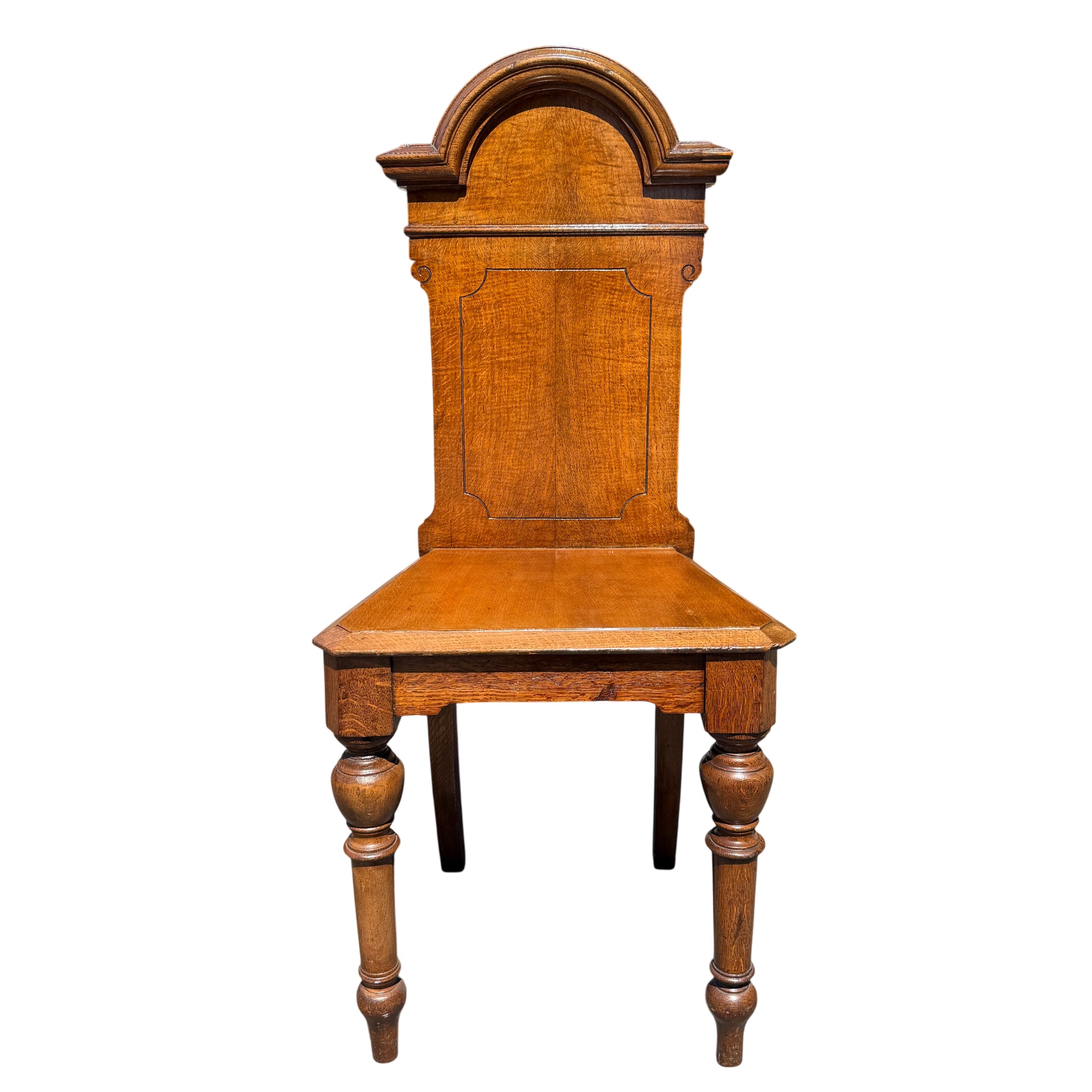 Front view of a Victorian oak hall chair showing shaped back and oak seat