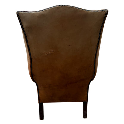 Worn wooden cabriole front legs and stretcher on a vintage leather Chesterfield-style chair