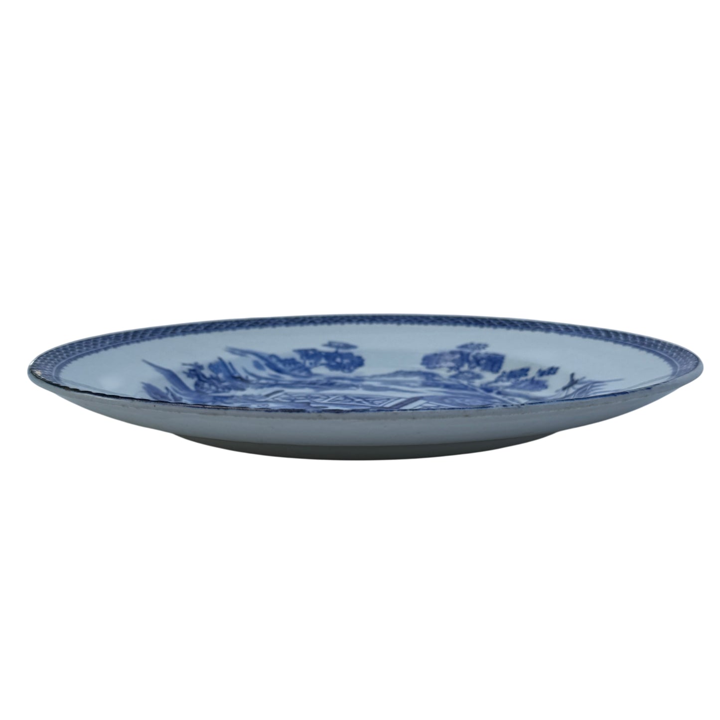 Three quarter view of antique porcelain plate showing crazing and surface wear