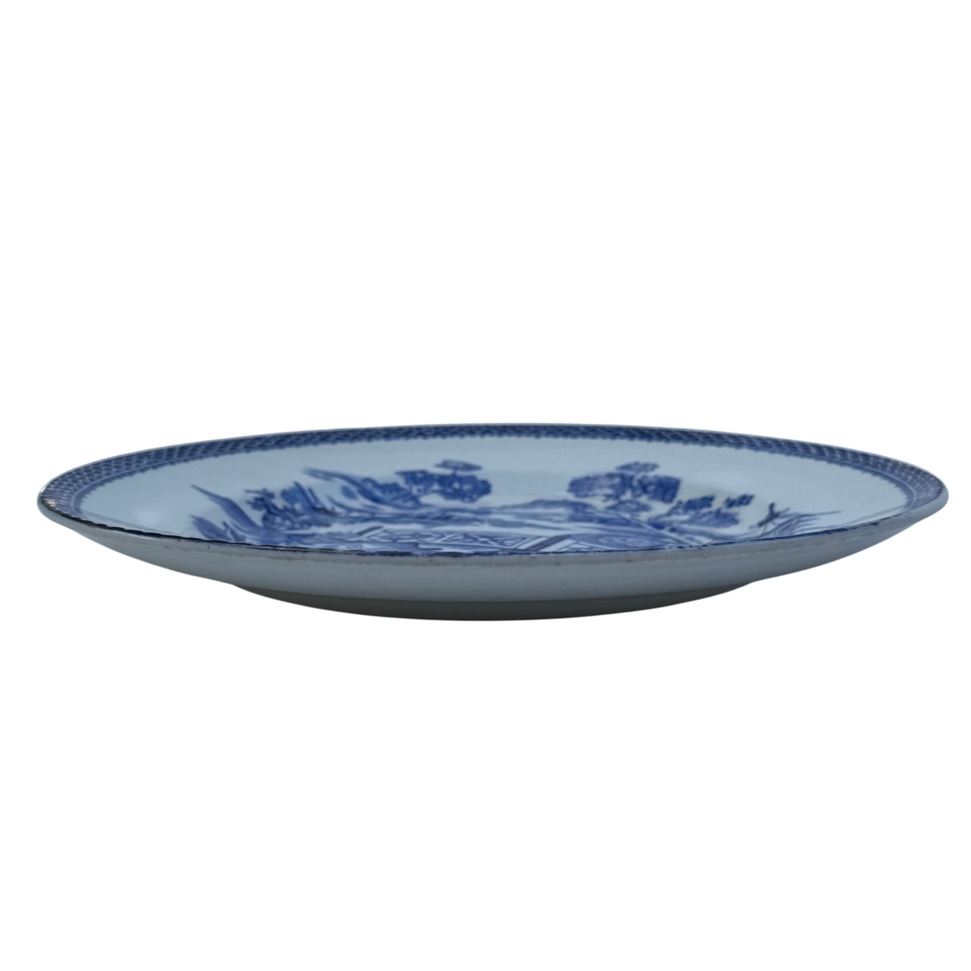 Three quarter view of antique porcelain plate showing crazing and surface wear
