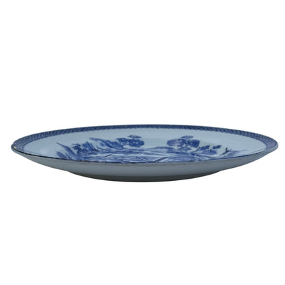 Three quarter view of antique porcelain plate showing crazing and surface wear